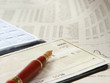 A pile of bills, checkbook, pen on the table.