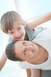Joyful toddler on back of his mother