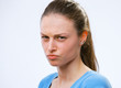 Portrait of a young woman scowling at you