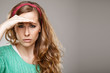 woman looking forward and having put her palm to forehead