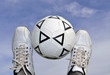 soccer ball between the legs on the background of the sky