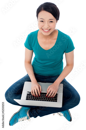 Photo: Cheerful attractive girl working on laptop Cheerful attractive girl working on laptop