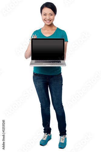 Photo: Salesgirl presenting brand new laptop for sale Salesgirl presenting brand new laptop for sale