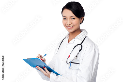 Photo: Pretty female doctor writing prescription Pretty female doctor writing prescription