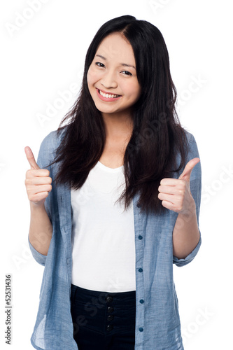 Photo: Smiling young girl showing two thumbs up Smiling young girl showing two thumbs up