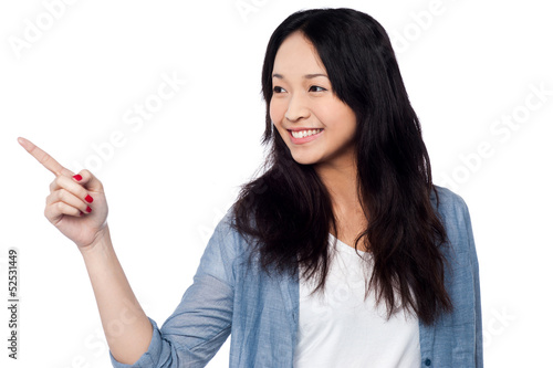 Photo: Young chinese girl pointing and looking outside Young chinese girl pointing and looking outside