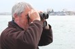 A white male using binoculars along the coast