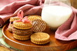 homemade cookies (sandwich) with milk on a wooden table