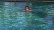Happy young man swimming in the pool
