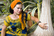 Blue-eyed woman with the african pigtails among tropical plants