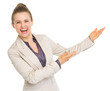 Smiling business woman pointing on copy space