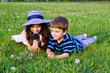 Kids with a magnifying glass on meadow