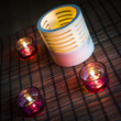 tea candles in wood and glass standing on reed mat
