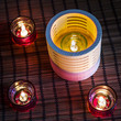 tea candles in wood and glass standing on reed mat