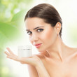 Foto: Gorgeous woman smiling and holding face cream Gorgeous woman smiling and holding face cream