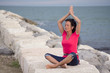 Schöne Frau bei Yogaübung am Meer