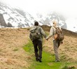 Couple of hikers with backpacks walking in the mountains