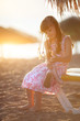 little girl sitting on the beach at sunset