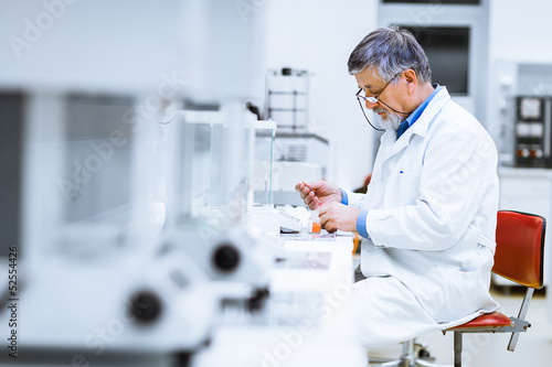 Photo: Senior male researcher carrying out scientific research in a lab Senior male researcher carrying out scientific research in a lab