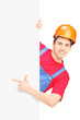 Young construction worker with helmet gesturing on a blank panel