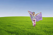 Asian woman running on green field