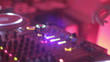 Female Dj performing set, tweaking track controls in nightclub