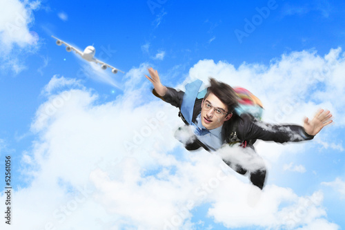 Photo: Young businessman flying with parachute on back Young businessman flying with parachute on back