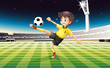 A boy in his yellow uniform playing soccer at the field