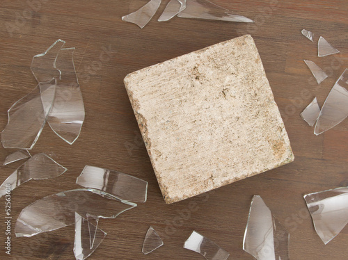 Photo: Brick with broken glass, violence concept Brick with broken glass, violence concept
