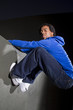 free runner scaling or climbing a wall at night to do parkour
