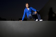 free runner scaling or climbing a wall at night to do parkour