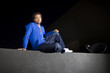 free runner scaling or climbing a wall at night to do parkour