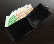 Euro in wallet on wooden background