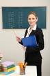 Portrait of teacher woman near chalkboard in classroom
