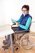 Photo: Woman with Tablet PC's in a wheelchair at the table Woman with Tablet PC's in a wheelchair at the table