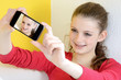 Schülerin fotografiert sich mit Smartphone