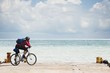 Men with a bicycle stands on the beach