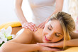 Wellness - Frau erhält Rückenmassage in Spa