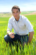Farmer kneeling in wheat field