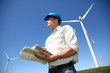 Engineer in wheat field checking on turbine production