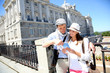 Couple reading traveler book by the Royal Palace of Madrid
