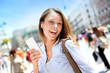 Cheerful girl using smartphone in town