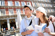 Tourists walking in La Plaza Mayor with traveler guide