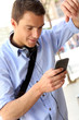 Photo: Man checking mails on smartphone in city street Man checking mails on smartphone in city street