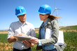 Engineers using tablet on wind turbine site