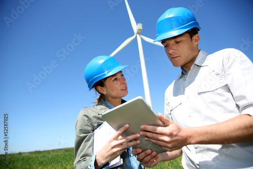 Photo: Engineers looking at wind turbine site with tablet Engineers looking at wind turbine site with tablet