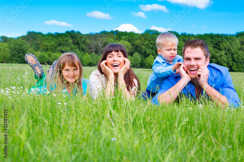Photo: junge familie lachend auf der wiese junge familie lachend auf der wiese