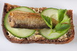 toast with butter, cucumber and sprats, close up, top view