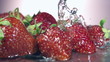 fresh strawberry dropped into water with splash on backgrounds