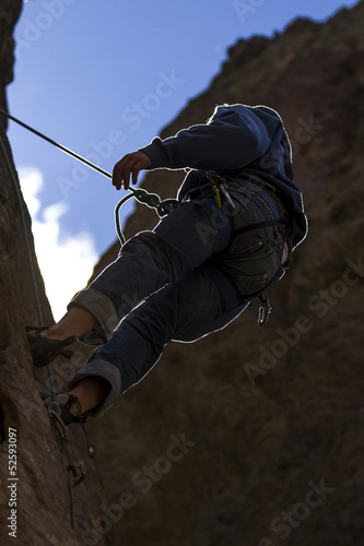 Photo: Escalador rapelando a cotralluz. Piedra, montaña, deporte. Escalador rapelando a cotralluz. Piedra, montaña, deporte.